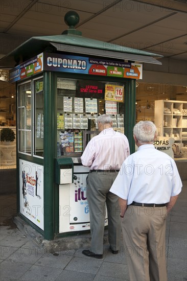 Two men waiting to purchase lottery tickets from a street booth, Seville, Spain, Europe