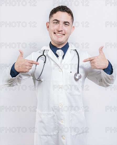 Satisfied young doctor pointing at himself on isolated background. Cheerful doctor pointing at himself isolated