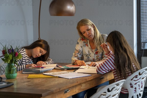 Homeschooling, during the lockdown in January 2021, mother helps her two daughters, at home, learning, school closures, distance learning, effects of the corona crisis in Germany