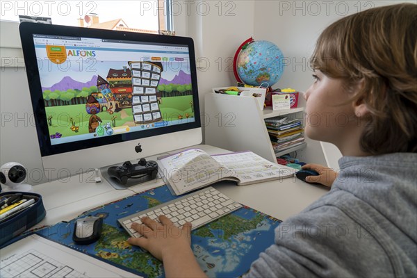 Young, primary school pupils, home learning, doing schoolwork, distance learning, virtual classroom, at home on the computer, effects of the corona crisis in Germany