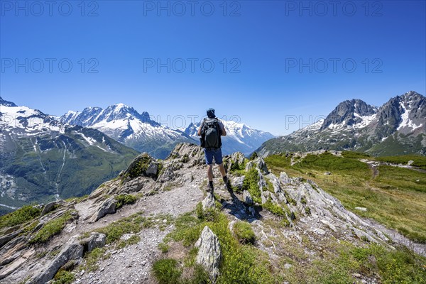 Mountaineer on hiking trail, mountain panorama with glaciated mountain peaks, Aiguille du Midi and Mont Blanc, Aiguille de Mesure and Aiguille de Chamois, hike to Aiguillette des Posettes, Chamonix, Haute-Savoie, France, Europe