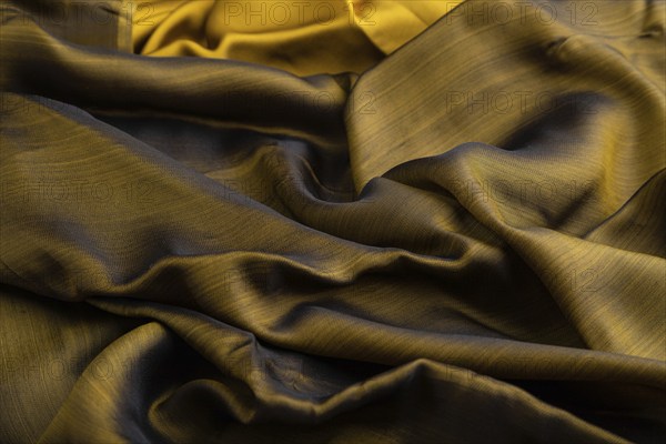 Fragment of yellow and green tissue. Side view, synthetic textile background and texture. wave concept, abstract