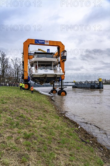 Craning the €6.3 million Sunseeker 88Y motor yacht, weighing 82 tonnes, in preparation for the world's largest water sports trade fair, Boot in Düsseldorf, luxury yachts are driven across the Rhine to the trade fair and brought ashore with the help of the Big Willi ship crane and transported to the exhibition halls on a low-loader, North Rhine-Westphalia, Germany, Europe