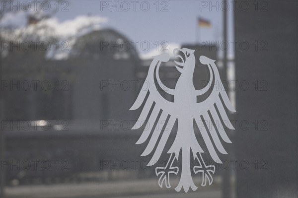 The federal eagle adorns the pane of the Federal Ministry of Education and Research, the Bundestag and Reichstag dome are visible in the reflection, in Berlin, 28 March 2024