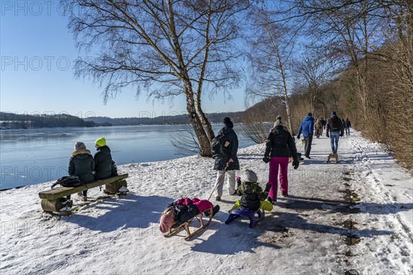 Winter in the Ruhr area, Lake Baldeney, snow-covered, partly frozen lake, walkers on the lakeside path, west bank, Essen, North Rhine-Westphalia, Germany, Europe