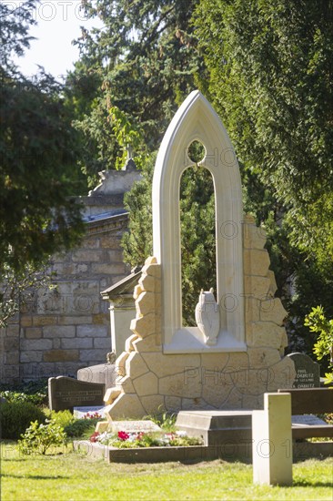 A new monument can be seen at Caspar David Friedrich's grave in Dresden's Trinitatisfriedhof cemetery to mark the 250th birthday of the most famous Romantic artist. The Gothic church window made of sandstone with an owl in rear view on the ledge. The construction was supported by the actor and Friedrich admirer Tom Pauls, Grave of Caspar David Friedrich, Dresden, Saxony, Germany, Europe