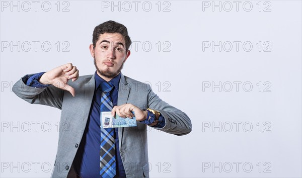 Business man holding banknote with thumb disapproving, man with money in hand and thumb down