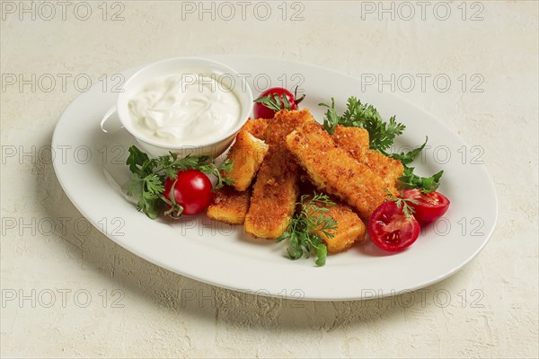 Fried fish nuggets, with white sauce, arugula and cherry, no people