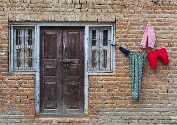 Clothe colourful laundry dry outside of a house. Nepalese brick wall traditional house