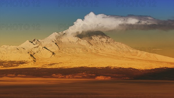 Eruption crater active volcano on Kamchatka Peninsula, winter volcano landscape at sunrise. Colorful picture with filter noise and grain, effect of old film, vintage instant color photo effect