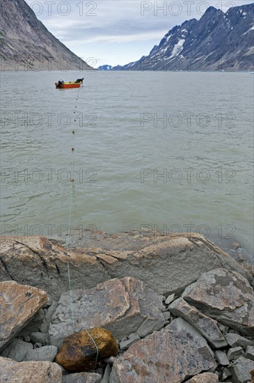 Inuit hunter sets net in fjord, near Inuit settlement Tiniteqilaaq or Greenlandic Tiilerilaaq, Sermilik Fjord, East Greenland, Greenland, North America