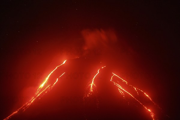 Volcanic landscape of Kamchatka Peninsula: night view of eruption Klyuchevskoy Volcano, current red hot lava flows on slope of active volcano. Eurasia, Russian Far East, Kamchatka Region, Klyuchevskaya Group of Volcanoes