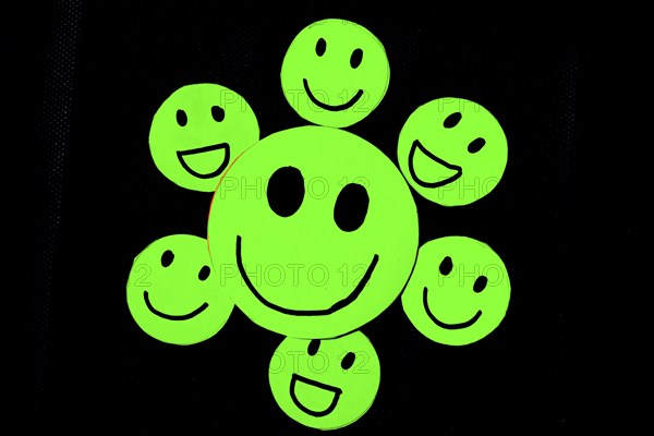 Cutout of green emoticons with smiley face on black background. Concept of well-being, good habits, health, personal care, happiness