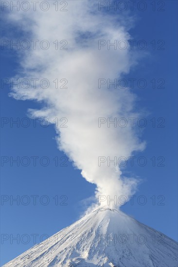 Winter volcanic landscape: active Klyuchevskaya Sopka (Klyuchevskoy Volcano), view of the top of volcanic eruption: emission from crater of volcano plume of gas, steam and ashes. Eurasia, Russian Far East, Kamchatka Peninsula, Klyuchevskaya Group of Volcanoes