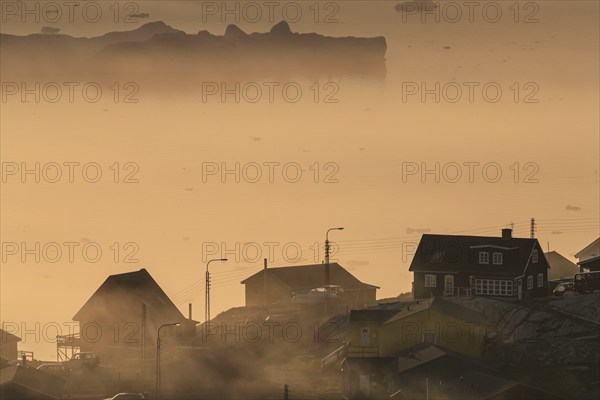 Inuit settlement in front of icebergs in the fog, midnight sun, summer, Ilulissat, Ilulissat Icefjord, Disko Bay, West Greenland, Greenland, North America