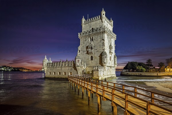 Belem Tower or Tower of St Vincent, famous tourist landmark of Lisboa and tourism attraction, on the bank of the Tagus River (Tejo) after sunset in dusk twilight with dramatic sky. Lisbon, Portugal, Europe