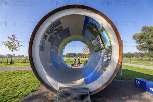 Original sewer pipe element of the Emscher sewer as an information stand in Emscherland, a new nature and water adventure park on the renaturalised Emscher, at the water crossing of the Emscher with the Rhine-Herne Canal, with lots of nature and recreational areas and information points on the Emscher conversion and regional nature, North Rhine-Westphalia, Germany, Europe