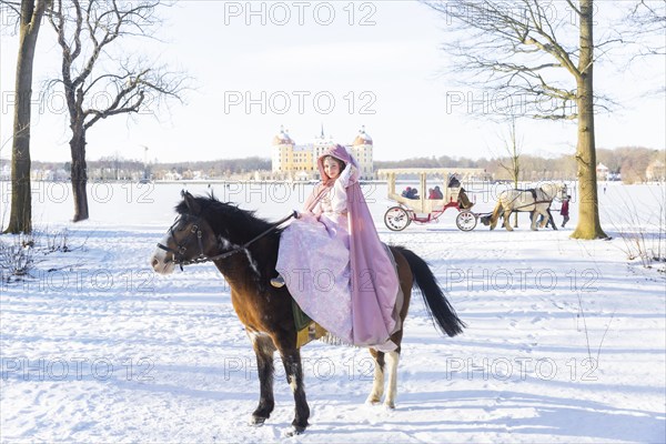 This year, the most popular fairytale film of all time is celebrating a special anniversary. At Moritzburg Castle, one of the film's locations, the exhibition on the cult film Three Hazelnuts for Cinderella is opening for the twelfth time - with an anniversary-worthy supporting programme and special exhibition. Model Tamara Kretschmer once again slipped into the coveted role of the legendary Cinderella with the ball gown. Here she rides the legendary film horse Catano, Moritzburg, Saxony, Germany, Europe