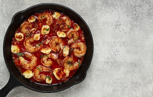 Greek saganaki, in an iron pan, saganaki with shrimp, shrimp in tomato sauce, with pepper and feta cheese, homemade, no people