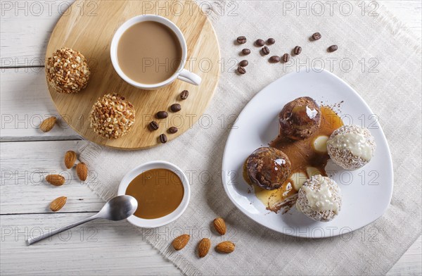 Energy balls cakes with chocolate caramel and coconut on white plate on linen napkin, top view