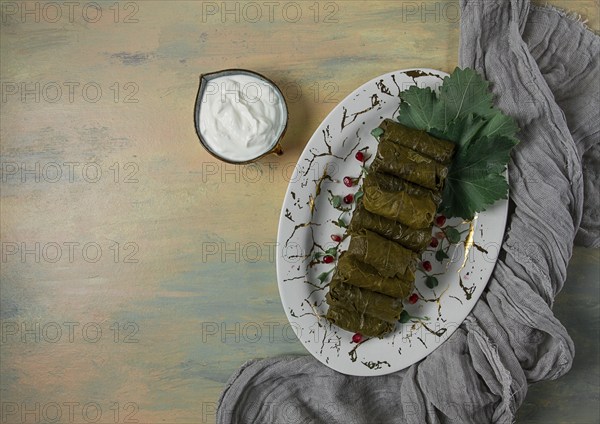 Dolma, cabbage rolls in grape leaves, Traditional Armenian dish, with white sauce, top view, close-up, selective focus