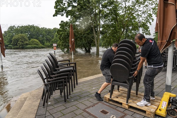 High water on the Ruhr, after long heavy rainfall the river left its bed and flooded the countryside and villages, the highest water level ever recorded, Flooded Ruhr promenade in Mülheim, caterers bring their furniture to safety, Mülheim an der Ruhr, North Rhine-Westphalia, Germany, Europe