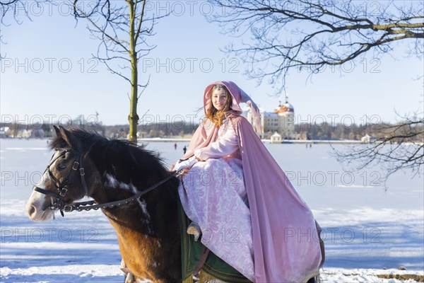 This year, the most popular fairytale film of all time is celebrating a special anniversary. At Moritzburg Castle, one of the film's locations, the exhibition on the cult film Three Hazelnuts for Cinderella is opening for the twelfth time - with an anniversary-worthy supporting programme and special exhibition. Model Tamara Kretschmer once again slipped into the coveted role of the legendary Cinderella with the ball gown. Here she rides the legendary film horse Catano, Moritzburg, Saxony, Germany, Europe