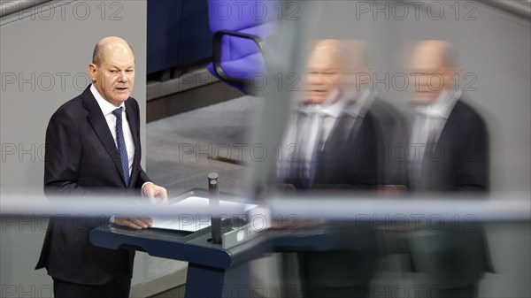 Federal Chancellor Olaf Scholz reflected in a pane of glass during his government statement in the German Bundestag, Berlin, 14 December 2022