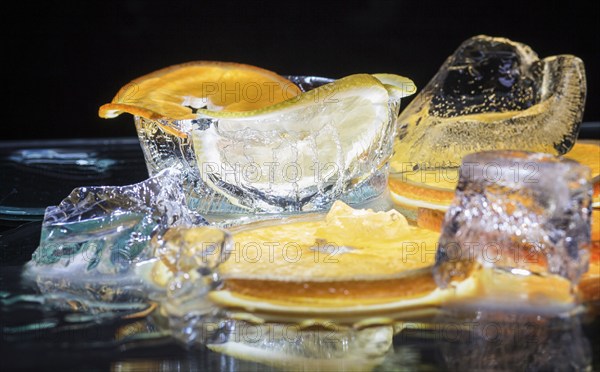 Transparent slices of fresh oranges and lemons on the glass with ice