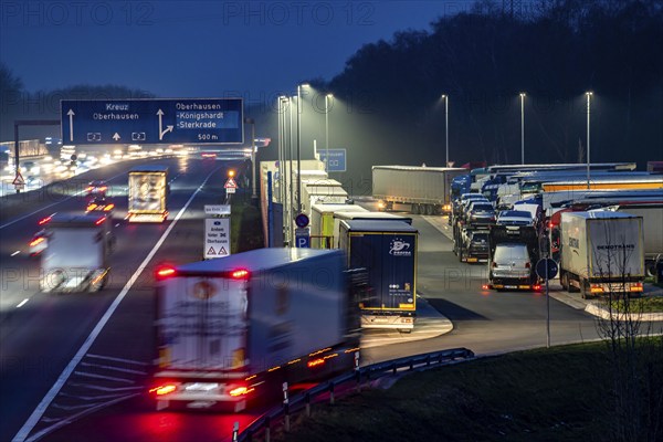 Heavy traffic on the A2 at the Schwarze Heide rest area, Bottrop, overcrowded car park for trucks in the evening, Bottrop, North Rhine-Westphalia, Germany, Europe