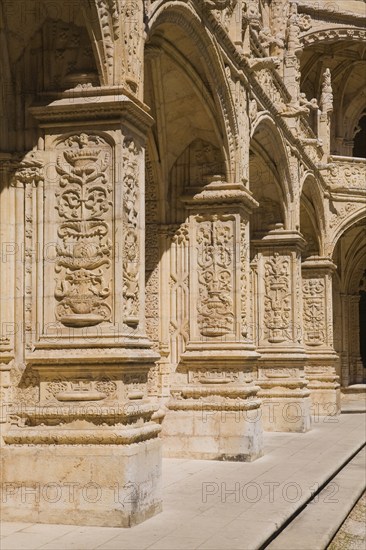 Old building with columns and arches decorated with architectural details in the inner courtyard at Jeronimos Monastery, Lisbon, Portugal, Europe