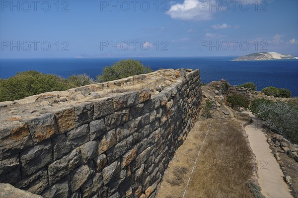 Ruin wall in an arid landscape with a view of the sea and a coastline in the background, Palaiokastro, Ancient fortress, 3rd and 4th century BC, above Mandraki, Nisyros, Dodecanese, Greek Islands, Greece, Europe