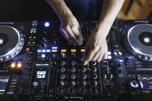 A DJ plays on a mixer and two Cdjs in Berlin, 14/08/2024