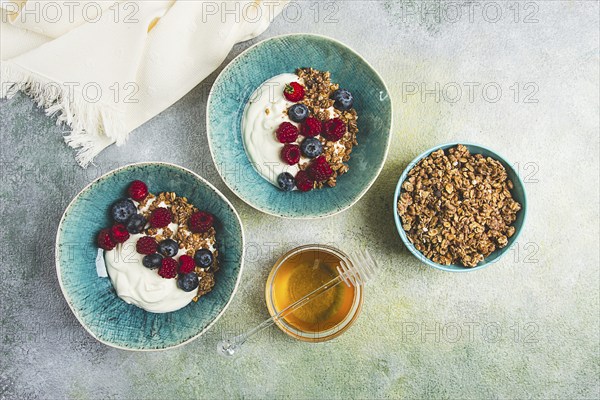 Breakfast, two bowls, yogurt, muesli with berries, and honey, homemade, no people