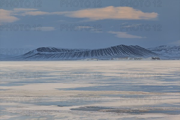 Frozen lake in a snowstorm, behind it Hverfjall crater, volcano, Myvatn, Iceland, Europe