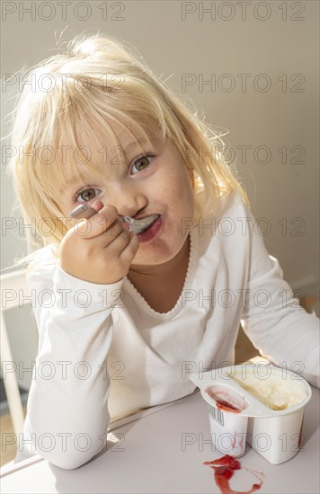 Portrait of blonde girl, 3 years old, having lunch in Ystad, Skåne County, Sweden, Scandinavia, Europe