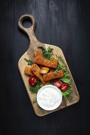 Fried fish nuggets, with white sauce, arugula and cherry, no people