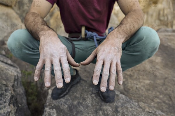 Close-up of a climber's chalk-covered hands, emphasizing grip and preparation for climbing