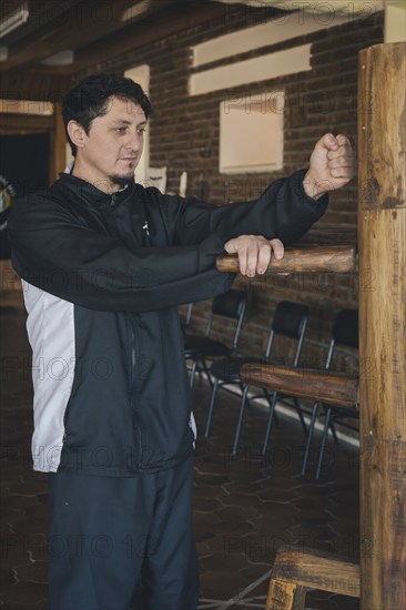 Male martial arts practitioner demonstrating the Lap Sao and Lap-dá technique, which emphasizes the ability to control the opponent through strategic grappling combined with a punch, showcasing the synergy between attack and defense characteristic of Wing Chun