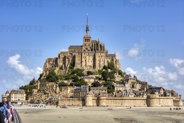 Famous French monastery on an island surrounded by sand under a blue sky, Le Mont-Saint-Michel