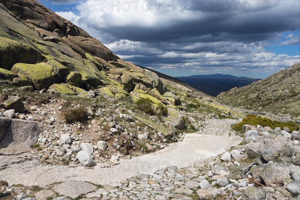 A stony path in a rocky mountain landscape under a cloudy sky, hiking area, Reserva national de Gredos, Garganta de Prado Puerte, Prado Puerte Gorge, Sierra de Gredos, Ávila, Avila, Madrid, Spain, Europe