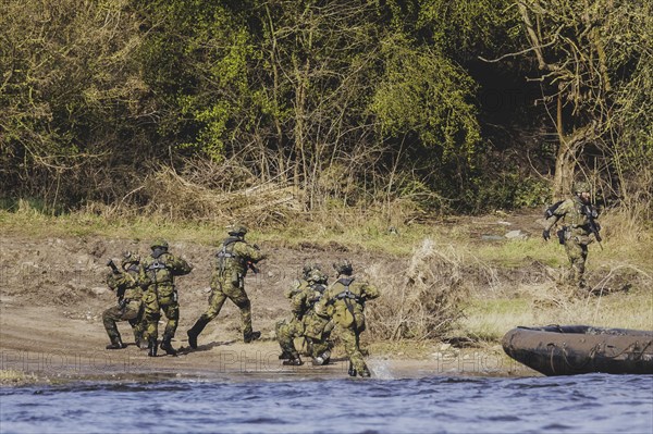 Czech and German soldiers launch an inflatable boat into the Elbe as part of the military exercise 'Wettiner Schwert' near Tangermünde, 26 March 2024. 'Wettiner Schwert' is part of the NATO Quadriga exercise