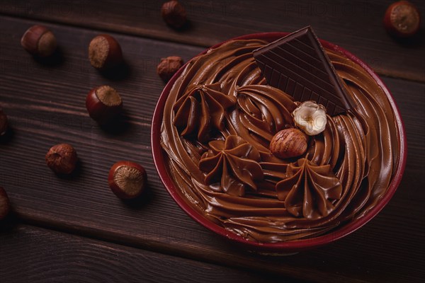 Chocolate nut paste, mousse, pasta, in a cup, on a wooden table, top view, selective focus, no people