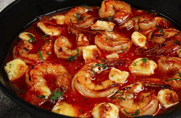 Greek saganaki, in an iron pan, saganaki with shrimp, shrimp in tomato sauce, with pepper and feta cheese, homemade, no people