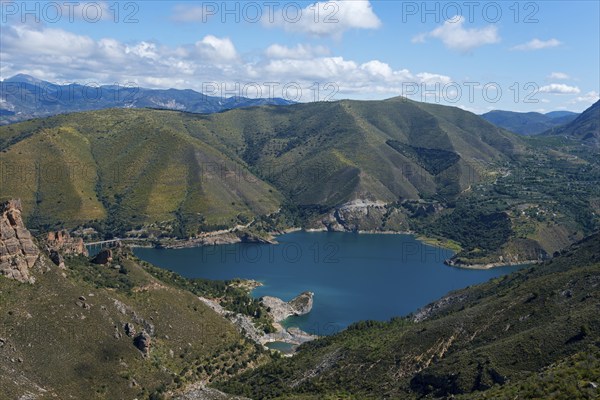 Large blue lake, surrounded by green mountains and hills, under a cloudy sky, reservoir, Embalse de Canales, Canales dam, Sierra Nevada, near Güéjar Sierra, Granada province, Andalusia, Spain, Europe