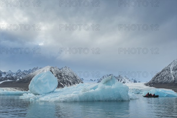 Dinghy with tourists, icebergs in front of glacier, -edge of Monacobreen, Liefdefjord, Woodfjord area, Spitsbergen Island, Svalbard and Jan Mayen archipelago, Norway, Europe