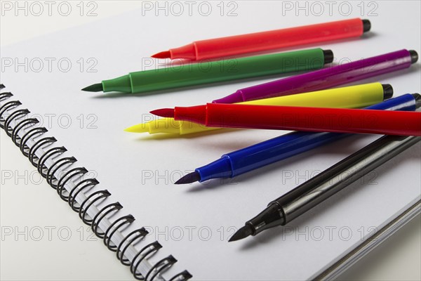 Watercolor pens brush, assortment, on a drawing album, artist's desk, top view, close-up, selective focus