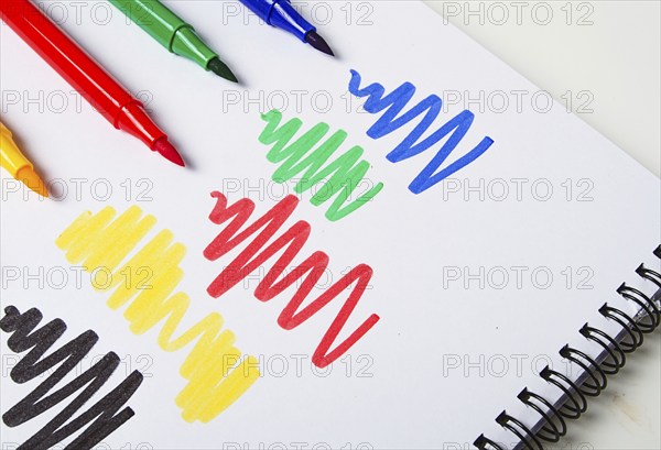 Watercolor pens brush, assortment, on a drawing album, artist's desk, top view, close-up, selective focus