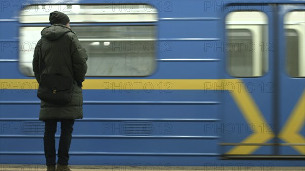 Passenger at the metro station. Blue and yellow train. Metro station stop