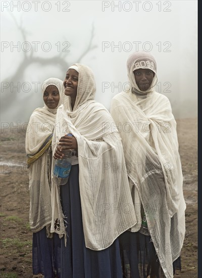 Three young Ethiopian pilgrims have arrived in the pilgrimage site of Lalibela after a long pilgrimage, Lalibela, Ethiopia, Africa